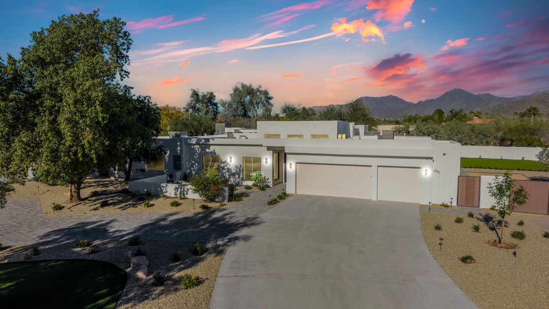 White modern home at sunset with mountains behind