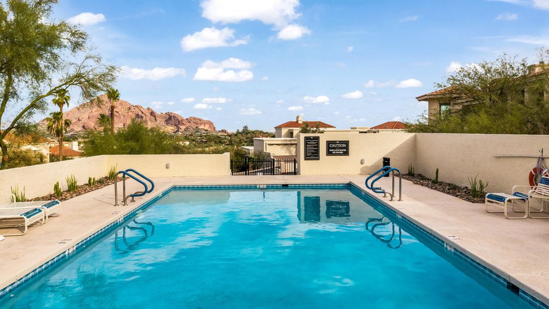 Community pool with Camelback Mountain in the distance under a blue sky