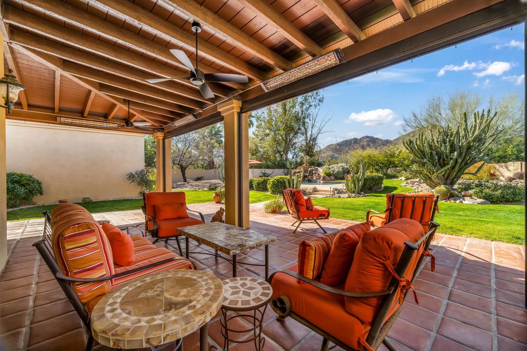 Covered patio with orange lounge chairs and a view to the mountains