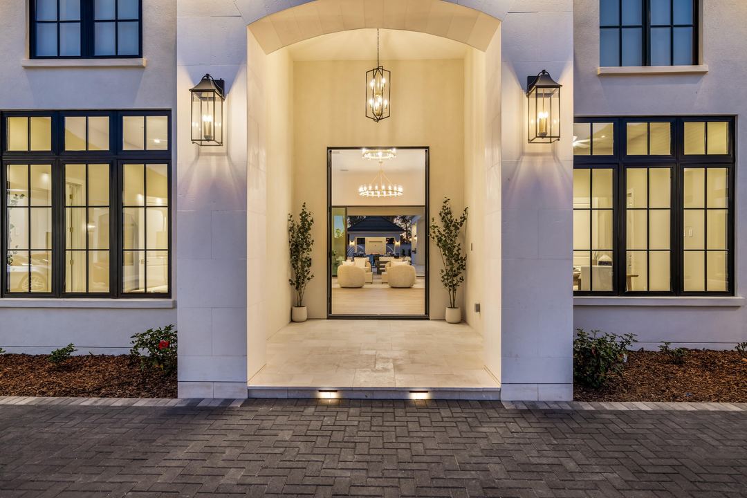 Glass entry framed by lanterns and black steel windows
