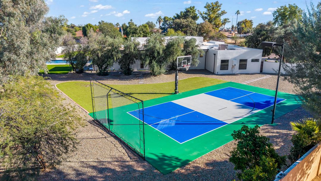Aerial of a blue and green pickleball court beside the house