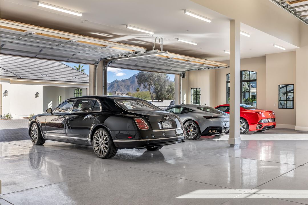 Glass-walled car gallery with a Bentley and a red Ferrari
