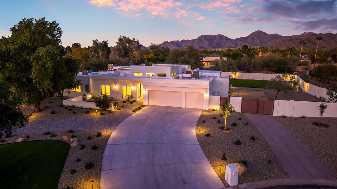 Lit drive curving up to the house at twilight