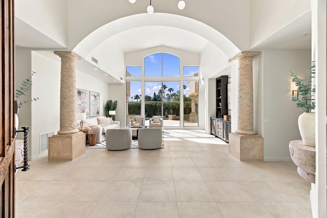 Great room framed by stone columns with two-story arched windows
