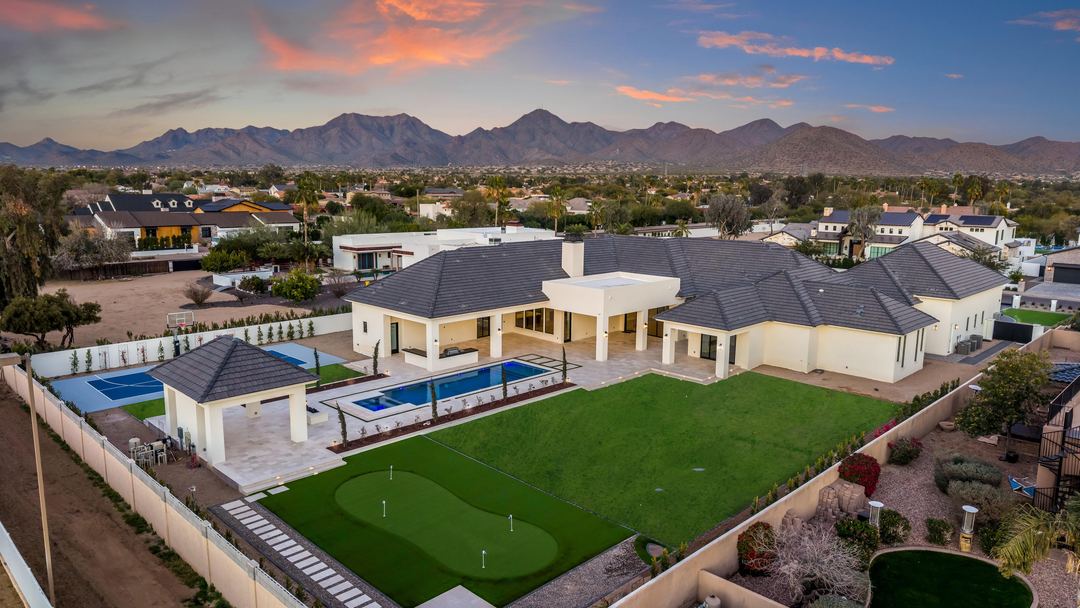 Twilight aerial over the backyard and putting green toward the mountains