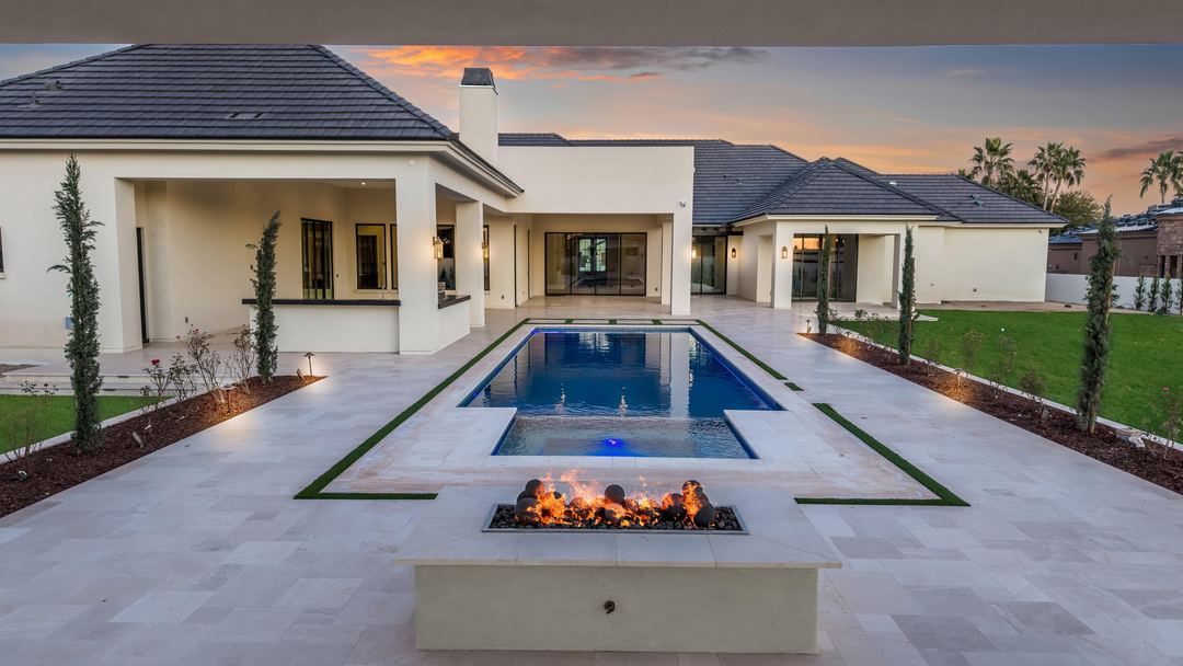 Low aerial over a fire feature and pool at dusk