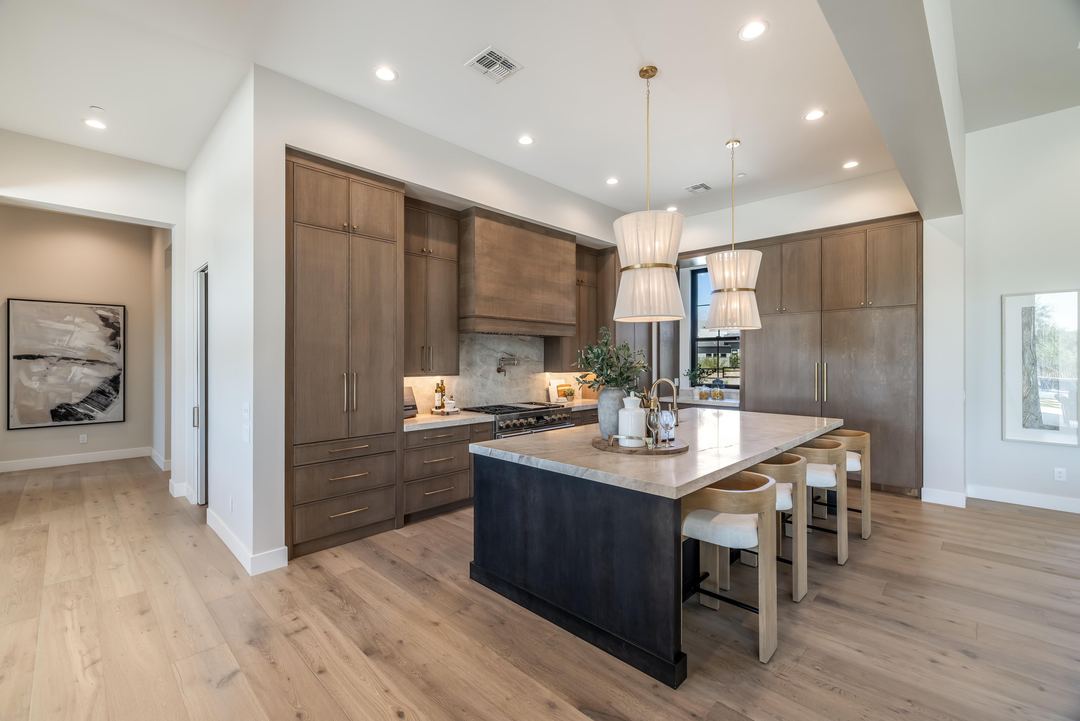 Kitchen with walnut cabinets, a dark island and woven pendants