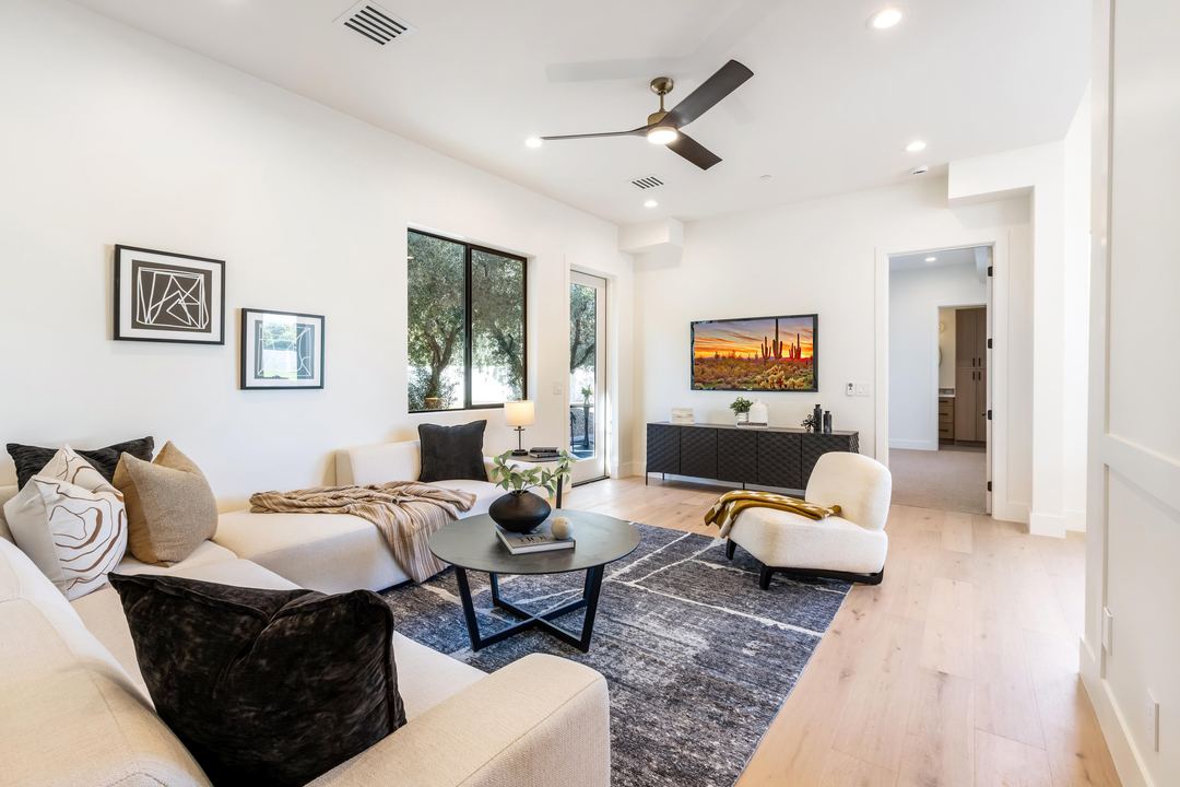 Living room with a cream sofa, a black coffee table and a desert print