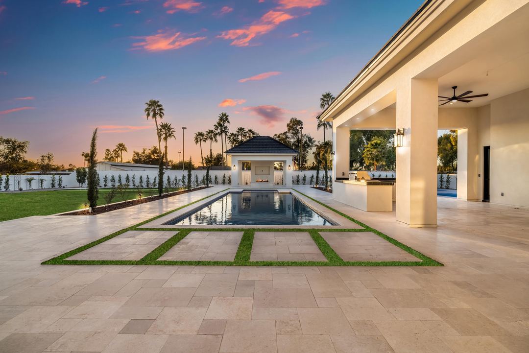 Pool and cabana at sunset framed by the covered patio