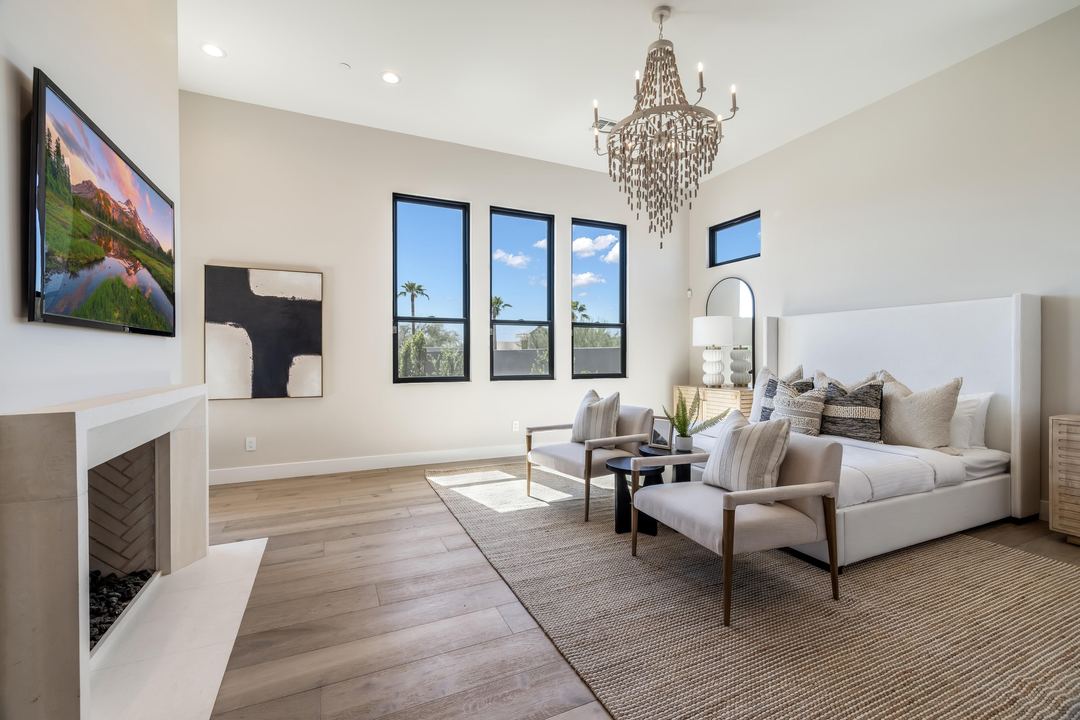 Primary suite with a fireplace, a sitting area and a beaded chandelier