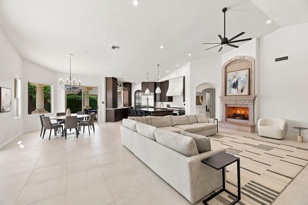Family room open to the kitchen, with a sectional and a carved fireplace