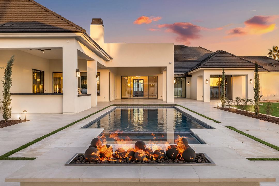 Fire feature at the head of the pool, with the house lit beyond