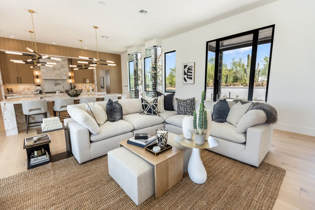 Living room with white sofas looking out to the desert through black-framed windows