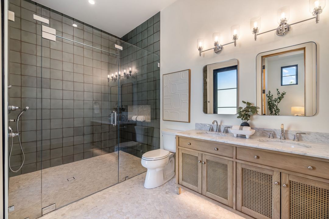 Bathroom with a glass shower, oak vanity and brass fixtures