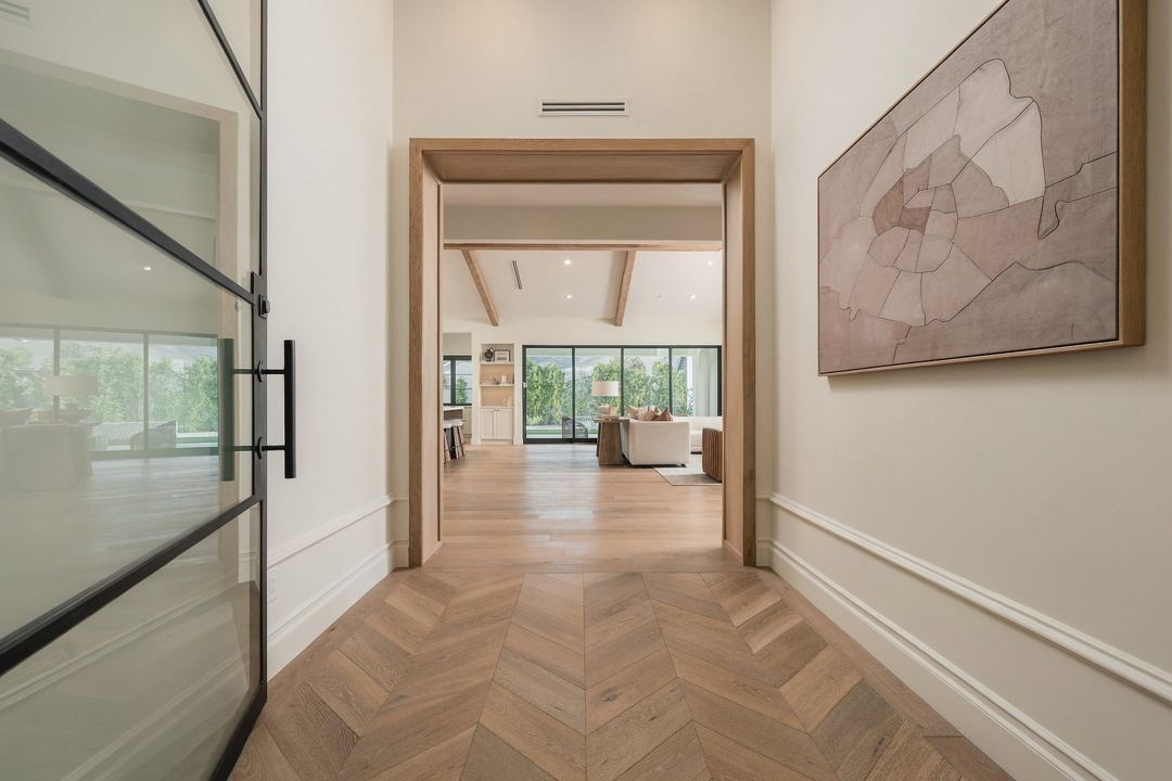 Entry hall with a herringbone oak floor, looking through to the great room and the yard