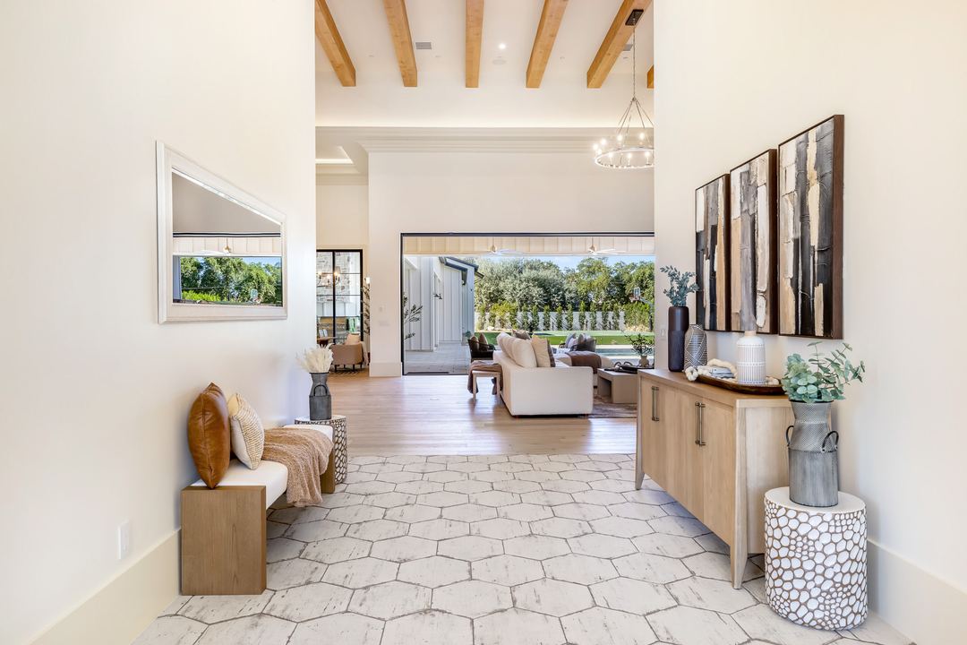 Entry hall with hex tile, a console and a view through to the great room