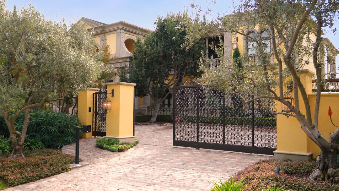 Iron gate and olive trees at the entrance to an estate