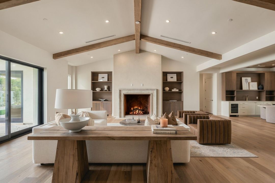 Living room with a stepped stone fireplace, a cream sectional and a walnut console