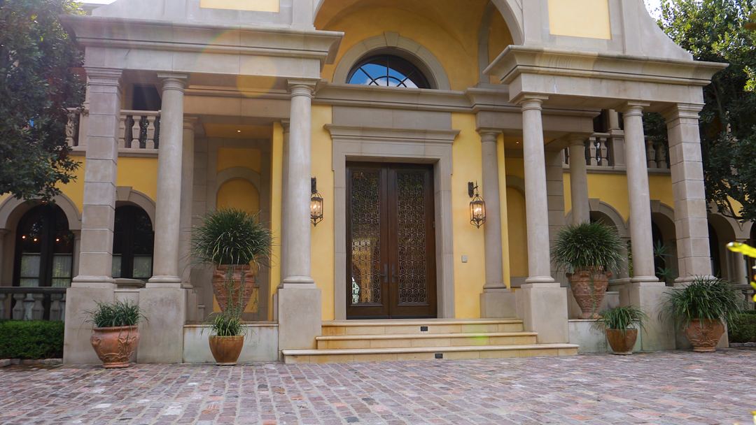 Columned entry and arched front door of a Mediterranean estate