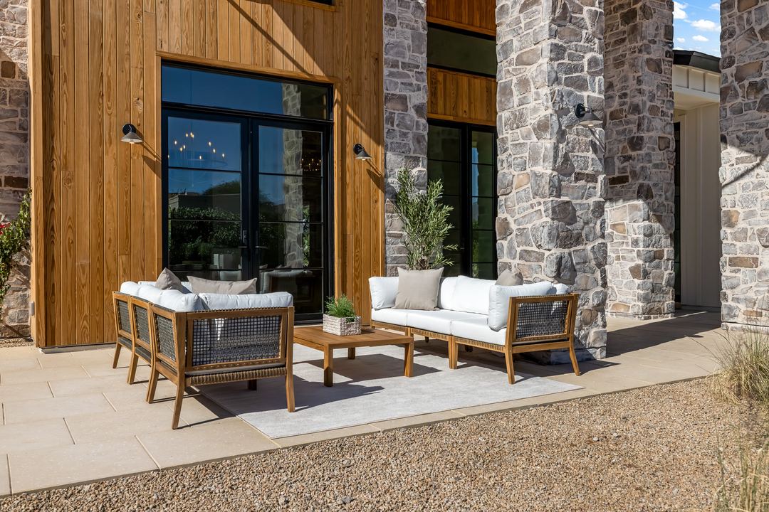 Covered patio with wood ceiling, stone columns and outdoor seating
