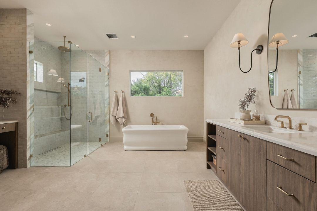 Primary bath with a freestanding tub, a glass shower and a walnut double vanity