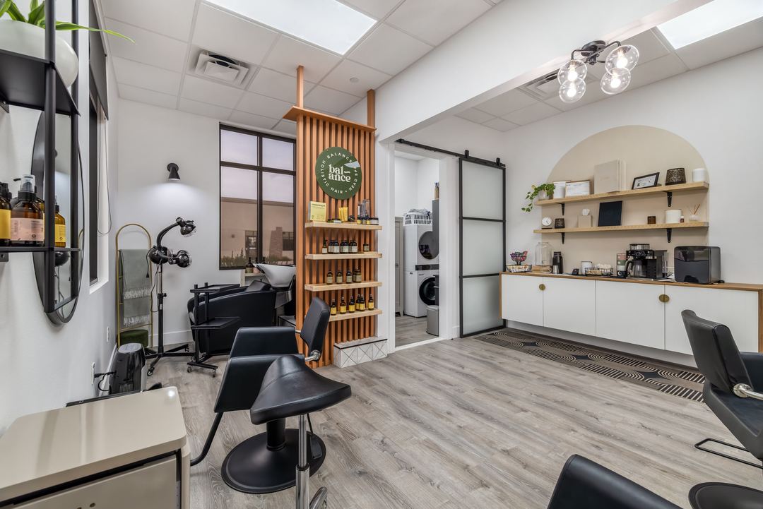 Salon suite with a white arch, oak shelving and a styling chair