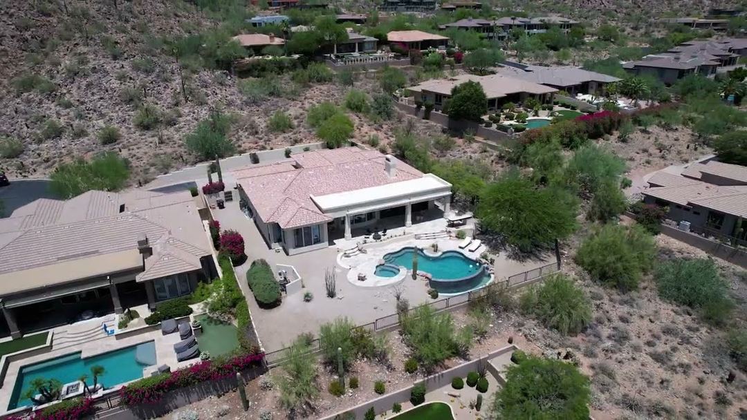 Aerial of hillside homes and pools on the mountain in Scottsdale, a frame from a listing film
