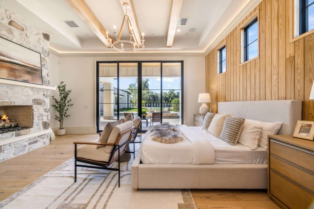 Real estate photography of a luxury master bedroom featuring a stone fireplace in Phoenix, AZ