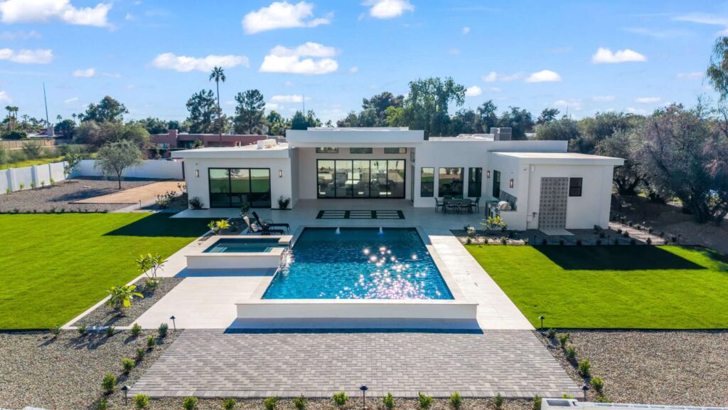 Exterior real estate photography highlighting a modern backyard pool area and lawn in Phoenix, AZ