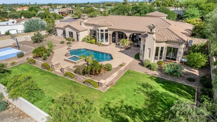 Real Estate Videography Services in Phoenix, AZ 5 High-angle real estate photography of a Mediterranean-style Phoenix, AZ luxury home with a swimming pool and patio